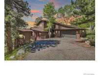 Charming home with lush greenery and an attached two-car garage at 30722 Eldora Ct, Evergreen, CO 80439