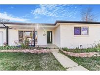 Charming front exterior featuring a garden and covered porch with comfortable seating at 135 Garnet St, Broomfield, CO 80020
