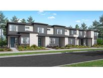 Modern townhome community with gray and white exteriors, landscaping, and paved street at 5773 N Jericho Way, Aurora, CO 80019