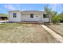 Charming one-story home with white siding, brick accents, and a well-manicured front yard at 9400 High St, Thornton, CO 80229