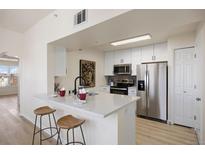 Bright kitchen features a breakfast bar with quartz counters and stainless steel appliances at 12820 Ironstone Way # 301, Parker, CO 80134