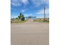 Charming single-story home featuring a covered front porch, attached garage, and spacious front yard at 58117 E 42Nd Dr, Strasburg, CO 80136