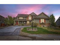 Charming two-story home with a well-manicured lawn, stone accents and a welcoming red front door at 22911 E Euclid Cir, Aurora, CO 80016