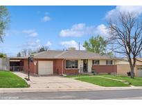 Ranch home features a brick exterior, mature trees, attached garage, and a well-manicured lawn at 2792 S Stuart St, Denver, CO 80236