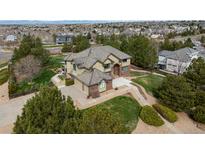 Expansive exterior elevation of home featuring a three car garage, pristine lawn, and mature trees at 6391 S Malaya St, Centennial, CO 80016