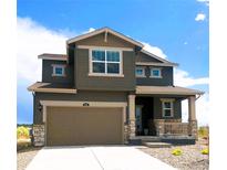Inviting two-story home showcasing a neutral color palette, stone accents, a wide driveway, and a covered porch at 996 Kolz Pt, Elizabeth, CO 80107