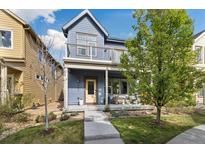 Charming blue two-story home with a inviting front porch and balcony, perfect for relaxing outdoors at 1702 W 66Th Ave, Denver, CO 80221