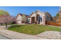 Charming home with a well-maintained lawn and beautiful blooming trees at 3494 S Otis Ct, Lakewood, CO 80227