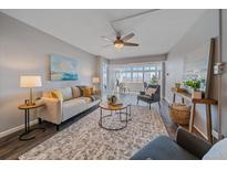 Inviting living room featuring a plush sofa, area rug, and a ceiling fan with view into sunroom at 800 N Washington St # 706, Denver, CO 80203