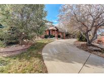 Brick home with landscaping and a long driveway at 1036 Lexington Ave, Westminster, CO 80023