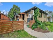 Charming brick home featuring a cozy front porch and well-maintained landscaping at 1111 Monroe St, Denver, CO 80206