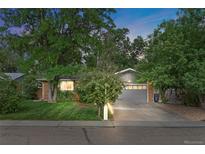 Brick ranch home with gray garage door, landscaping, and a well-manicured lawn at 1746 Shavano St, Longmont, CO 80504