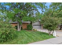 Charming single-story home with a well-manicured lawn and mature trees providing ample shade at 1746 Shavano St, Longmont, CO 80504