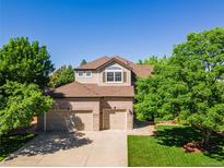 Charming two-story home with a three-car garage, lush landscaping, and a well-maintained front yard at 10565 Kalahari Ct, Lone Tree, CO 80124