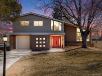 Charming home featuring a red front door, brick accents and a well-manicured lawn at 7744 S Gaylord Way, Centennial, CO 80122