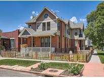 Attractive home featuring a front porch, brick accents, and well-maintained lawn at 2775 California St, Denver, CO 80205