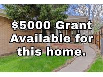 Charming brick home featuring a well-maintained lawn and mature tree, presenting an inviting curb appeal at 3667 Hudson St, Denver, CO 80207