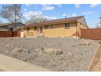 A charming single-story brick home featuring a well-maintained front yard with rock landscaping, and classic design elements at 1001 Dakin St, Denver, CO 80221
