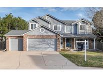 Charming two-story home featuring a brick and siding exterior, a well-maintained front yard, and an attached two-car garage at 5294 S Espana St, Centennial, CO 80015