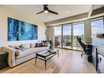 Bright living room with modern furnishings, hardwood floors, and a large balcony overlooking the neighborhood at 9019 E Panorama Cir # D218, Englewood, CO 80112