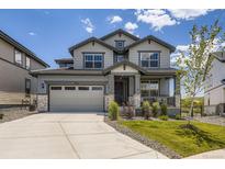 Charming two-story home showcasing a manicured lawn, neutral-toned exterior, and a welcoming front porch at 15210 W Eastman Ave, Morrison, CO 80465