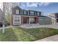 Charming two-story home with brick and green siding, a well-manicured lawn and a two car garage at 1150 W 127Th Ct, Denver, CO 80234