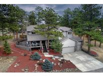Charming two-story home with a well-manicured yard and inviting deck, nestled among mature trees at 1334 Solitude Ln, Evergreen, CO 80439