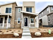 Modern two-story home featuring stone accents, a black front door, and well-manicured landscaping at 6632 N Nepal Ct, Aurora, CO 80019