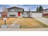 Charming home with a red front door, gray brick and siding, and a well-maintained front yard at 218 Pikes Peak Pl, Longmont, CO 80504
