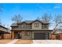 Charming two-story home showcasing neutral siding, a black garage door, and a cozy covered porch at 501 Lois Dr, Louisville, CO 80027