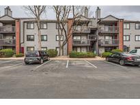Exterior view of the apartments with a parking lot and landscape with trees and bushes at 6388 Oak Ct # 203, Arvada, CO 80004