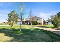 Charming home featuring a spacious front yard, long driveway and a combination of brick and vinyl siding at 29881 E 128Th Ave, Commerce City, CO 80022