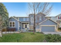 Charming two-story home featuring blue siding, a well-manicured lawn, and an attached two-car garage at 2660 Timberchase Trl, Highlands Ranch, CO 80126