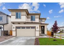 Inviting two-story home featuring a spacious driveway and beautifully landscaped front yard at 9297 Truckee Ct, Commerce City, CO 80022
