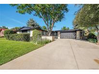 Charming brick home featuring a well-maintained front yard, mature trees, and a spacious driveway at 7018 Reed Ct, Arvada, CO 80003