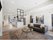 Bright living room featuring an open layout to the kitchen and a modern decor with city artwork at 4432 Umatilla St, Denver, CO 80211