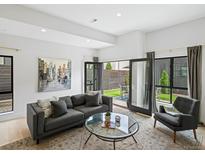 Bright living room featuring modern decor, stylish furniture, and seamless indoor/outdoor flow to a private patio at 4432 Umatilla St, Denver, CO 80211