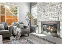 Inviting living room features a stone fireplace and comfortable seating area by bright windows at 1929 S Xanadu Way, Aurora, CO 80014