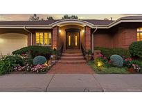 Inviting brick home exterior featuring manicured landscaping and a charming arched entryway with double doors at 400 S Steele St # 64, Denver, CO 80209