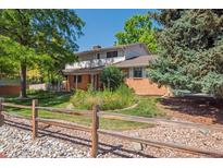 Charming two-story brick home featuring a well-manicured lawn and delightful flower garden at 7351 S Sheridan Ct, Littleton, CO 80128