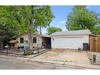 Charming home featuring a large tree, an American flag, and a detached garage at 6314 W 92Nd Pl, Westminster, CO 80031