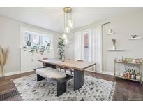 Bright dining room with a stylish rug, wooden table, bench, and a modern light fixture at 142 N Logan St, Denver, CO 80203