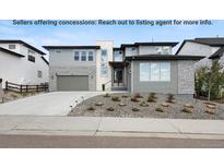 Beautifully landscaped two-story home with stone and gray siding at 455 Rogers Way, Castle Rock, CO 80104