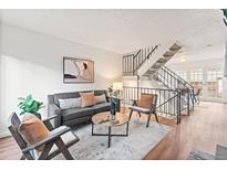 Inviting living room with modern furnishings and a stylish staircase leading to the upper level at 2297 S Oswego Way, Aurora, CO 80014