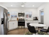 Bright kitchen features stainless appliances, white cabinetry and subway tile backsplash and a breakfast nook at 4463 Steele St, Denver, CO 80216