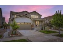 Charming home featuring a two-car garage, covered front porch, and well-maintained landscaping at 1063 Sandstone Cir, Erie, CO 80516