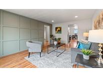 Inviting living room with modern decor, wood floors, and stylish gray accents at 8661 W 32Nd Pl, Wheat Ridge, CO 80033