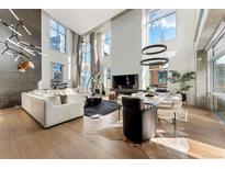 Bright and airy living room with high ceilings, large windows, and hardwood floors at 1610 Little Raven St # Ph6, Denver, CO 80202