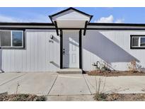 Inviting front entrance with a white door and well-maintained concrete walkway at 6931 Forest St, Commerce City, CO 80022