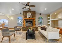 Inviting living room with stone fireplace, ceiling fan, and cozy seating arrangement at 205 Beech St, Hudson, CO 80642